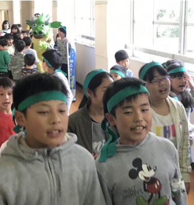 緑のはちまきをつけ、校内でいじめ防止について呼びかける子どもたち